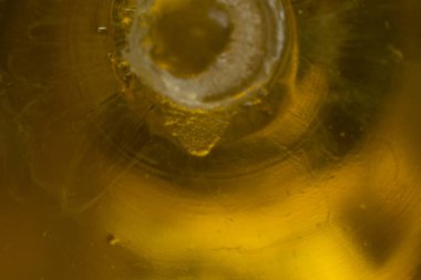 Makro fotoğraf. Sarı bitkisel yağ ile plastik şişe dibinde. Site hakkında mutfak, macrophotography, sanat, soyutlama, gıda sanayî için.