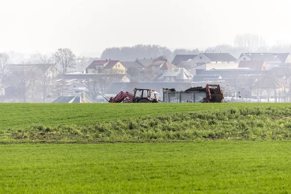 トレーラー付けトラクター自然肥料と受精のフィールド 牛糞は わらと混合 村の家 ポーランドのポドラシェ県 — ストック写真