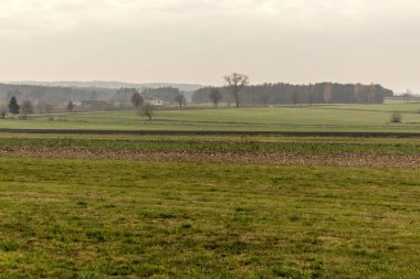 Geç sonbaharda. Yeşil çayırlar ve ön planda sürülmüş alanlar. Yalnız tuğla ev içinde belgili tanımlık geçmiş. Site agroindustry, tarım, hava durumu, mevsim hakkında.