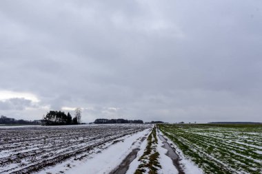 Tarıma elverişli arazi ve çayır arasında ülke yolda bazı kar var. Yolda su birikintileri. Orman içinde belgili tanımlık geçmiş. Kış başında Avrupa'da.