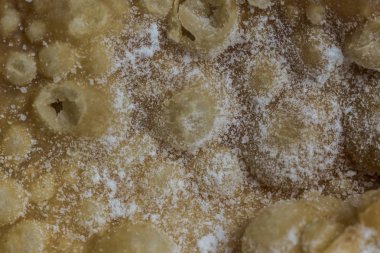 Macrophoto. Avrupa tatlı melek kanatları. Teknoloji tur derin kızarmış hamur ilginç ile pudra şekeri şeritler. Site hakkında mutfak, hamur işleri, tatlılar.
