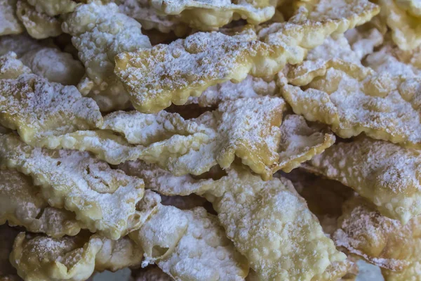 Kapat-up.Sweet tatlı melek kanatları. Derin yağda kızartılmış hamur şeritler ile pudra şekeri serpilir. Bölgesel mutfak pişirme, tatlılar hakkında bir site için arka plan.