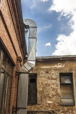 Restoranın mutfağından metal hava kanalı, tuğla duvara döşenmiş. Eski evin avlusu. Mimari hakkında site , mutfak .