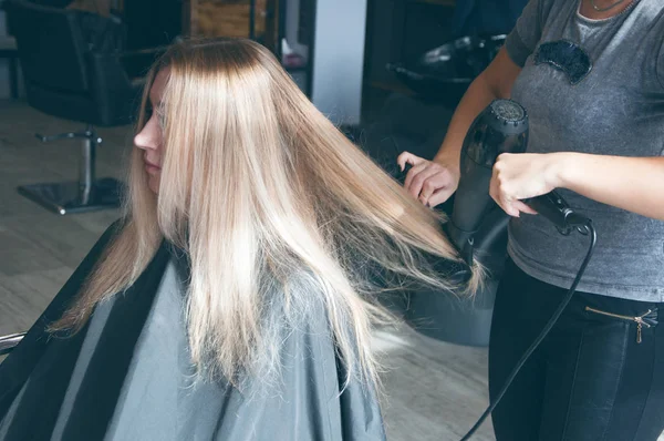 Güzel bir Avrupa Sarışın kız bir güzellik salonda bir saç modeli yapmak