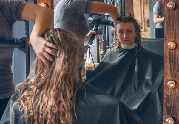 Güzel bir Avrupa Sarışın kız bir güzellik salonda bir saç modeli yapmak