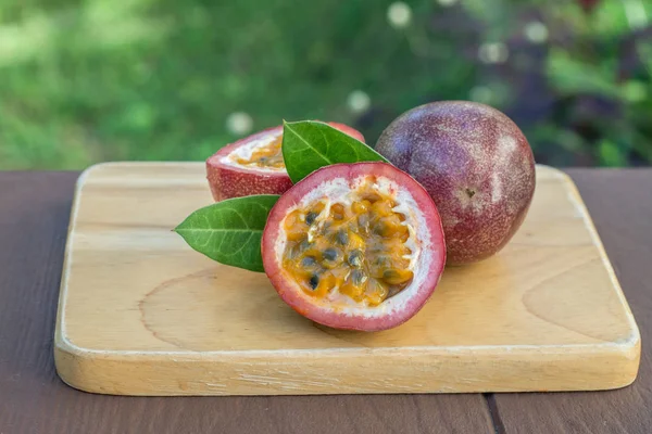 Passievruchten op de houten tafel op de achtergrond van de tropische tuin Stockfoto