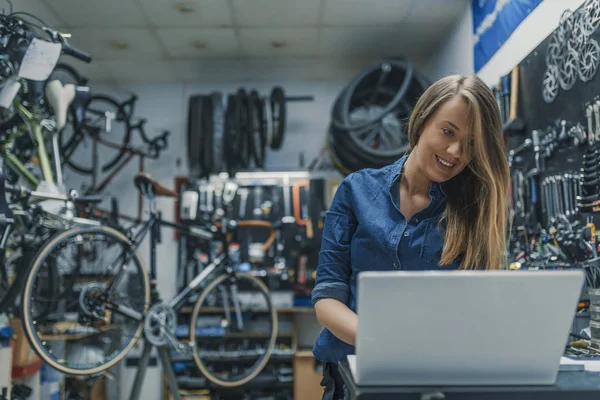 Yaratıcılık bir süreçtir. Bir dizüstü bilgisayarda çalışan kadın makinist. Kadın bisiklet tamircisi. Kadın makinist Bisiklet deposunda. Dizüstü bilgisayar ile genç kadın makinist