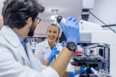 Genç öğrenciler Kimya laboratuarında çalışıyor. Bir laboratuar ortamında araştırma iki bilim adamı. Mikroskop slayt seyir bilim adamı