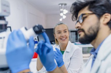 İki bilim adamları laboratuarda çalışıyoruz. Genç bilim adamları klinik laboratuvar ve Not almak test veya araştırma yapmak mikroskop ile. Bilim, kimya, teknoloji, biyoloji ve insanlar kavramı