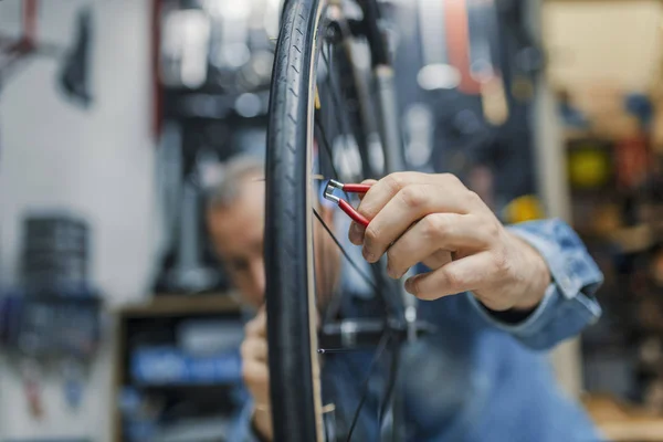自行车服务 熟练修理自行车 自行车技工在车间修理过程中 时尚的自行车技工在车间做他的专业工作 — 图库照片