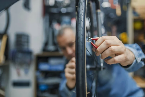 自行车服务 熟练修理自行车 自行车技工在车间修理过程中 时尚的自行车技工在车间做他的专业工作 — 图库照片