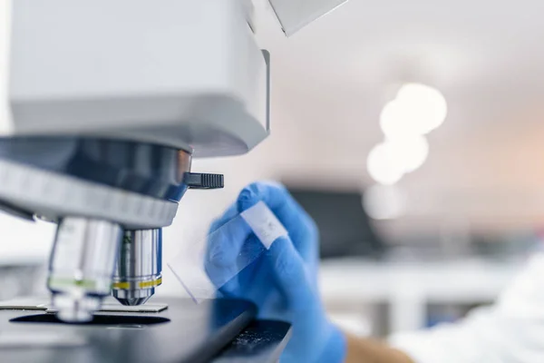 Metal objektif Laboratuvarı mikroskopla yakın çekim shot. Bilim adamı elle laboratuvar mikroskop yakın çekim vurulmuş. Laboratuvar mikroskop mikroskop ile erkekte slayt el