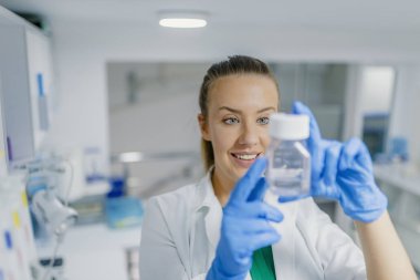 Genç kadın laboratuvar teknisyeni bilim araştırma yürütmektedir. Kadın araştırmacı bir kimya laboratuarında araştırma deneyler yürütmek. Bir kadın bilim adamı araştırmacı Kimya laboratuarında araştırma yapma