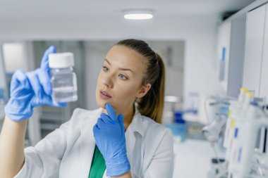 Kimya laboratuarında araştırma yerine getiren bir kadın araştırmacı portresi. Tıbbi Laboratuar, araştırma ve analiz. Laboratuvar, laborant bir örnek hazırlar.