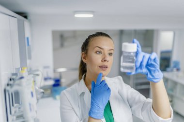Kimya laboratuarında araştırma yerine getiren bir kadın araştırmacı portresi. Tıbbi Laboratuar, araştırma ve analiz. Laboratuvar, laborant bir örnek hazırlar.