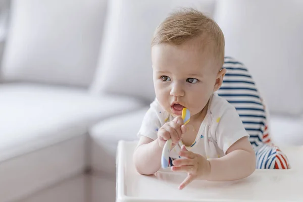 スプーンで赤ちゃん 餌と人コンセプト スプーン ハイチェアに座っていると 家で食べると赤ちゃん 高い椅子に幸せ子供男の子の肖像画 — ストック写真