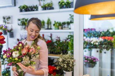 Çiçekler, yeşil yaprak el taze bahar zengin demet. İşyerinde kadın çiçekçi: genç ve güzel kadın moda modern buket farklı çiçek yapma. Çiçekli atölyesinde çalışan kadınlar