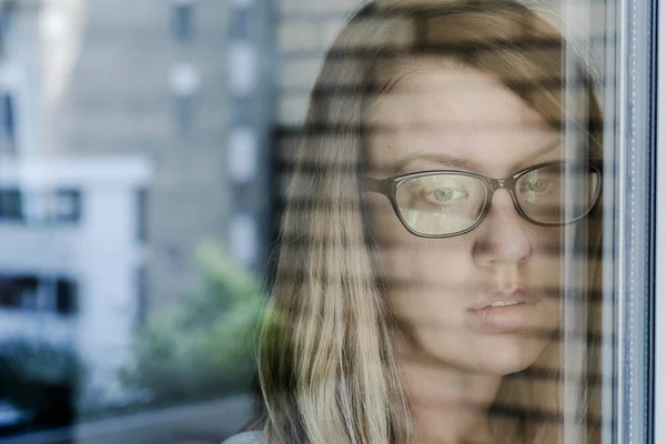 Ensam eftertänksam sorg flicka är sorgligt vid fönstret — Stockfoto