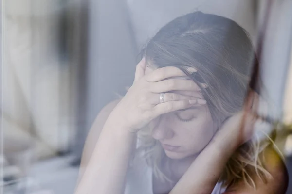 Solo pensativo tristeza chica es triste en la ventana — Foto de Stock