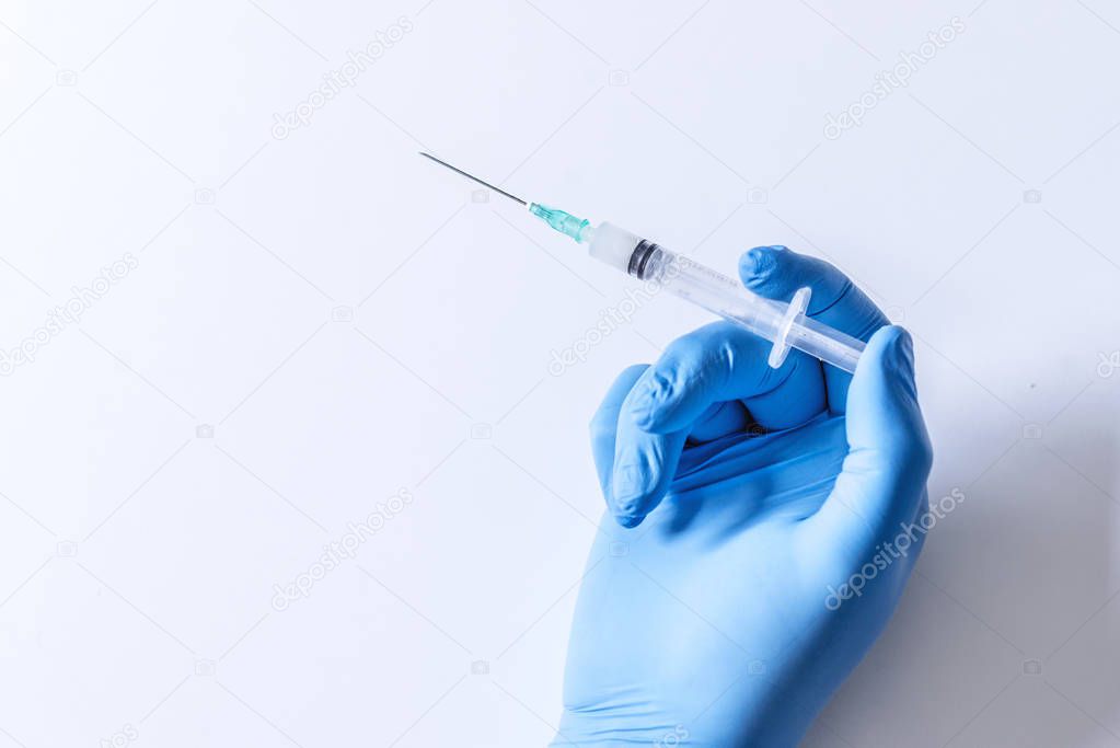 Hand holding syringe and vaccine. Syringe, medical injection in hand, palm or fingers. Medicine plastic vaccination equipment with needle. Nurse or doctor. Liquid drug or narcotic. Health care in hospital.