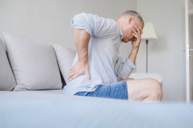 Adam evde sırt ağrısı acı. Acı acı arka tarafta veya dizginleri evde mutsuz olgun adam. Kişi, sağlık ve sorun kavramı 