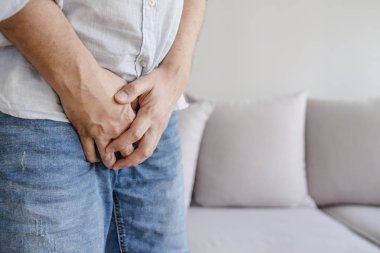 Pee - üriner inkontinans kavramı istediği onun kasık tutan elleri olan bir adam. Hasta adam prostat kanseri, prostat iltihabı, erken boşalma, doğurganlık, ereksiyon veya mesane sorunu