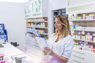 Kadın eczacı İlaç eczanede dijital tablet kullanırken arama 
