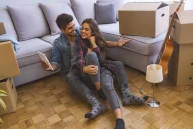 Genç çift yeni evinde dijital tablet kullanma 