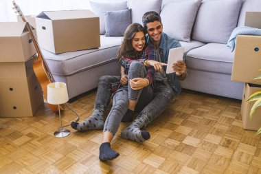 Genç çift yeni evinde dijital tablet kullanma 