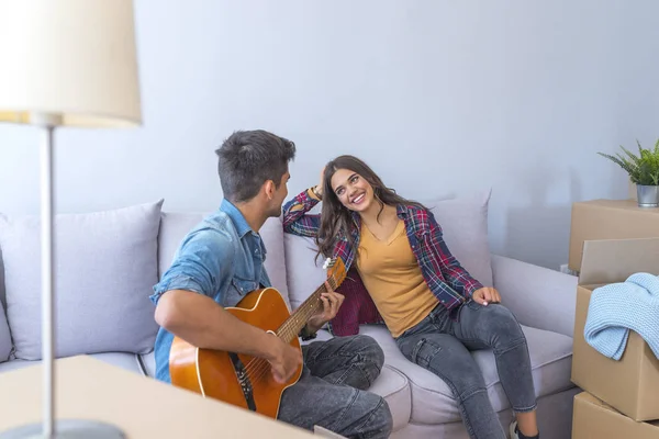 Jovem Tocando Guitarra Para Namorada Nova Casa — Fotografia de Stock