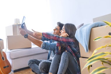 Genç çift yeni evinde dijital tablet kullanma 
