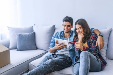 Kredi kartı ve yeni ev dijital tablet ile genç Çift