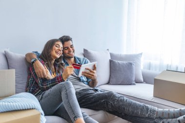 Kredi kartı ve yeni ev dijital tablet ile genç Çift