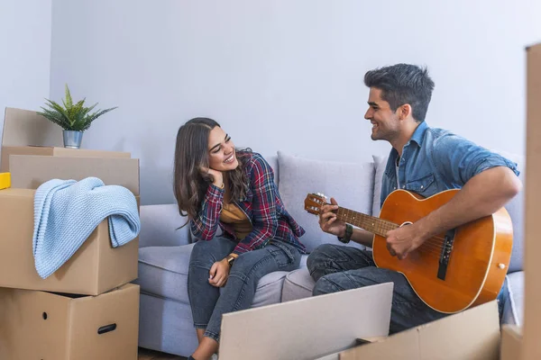 Jongeman Gitaarspelen Aan Vriendin Nieuwe Woning — Stockfoto