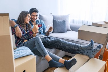 Kredi kartı ve yeni ev dijital tablet ile genç Çift