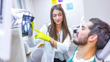 Kadın dişçi diş ofiste hasta x-ray görüntü için gösterilen