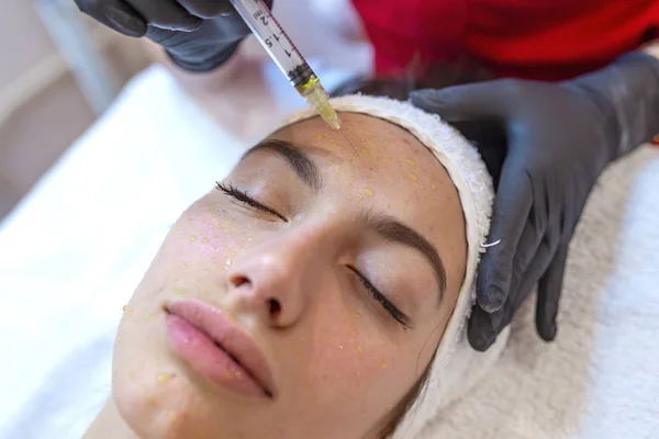 Young woman getting mesotherapy in spa salon