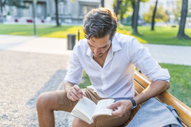 Genç adam okuma kitabı Şehir Parkı