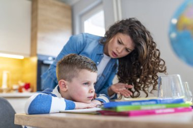 Mother scolding little boy for poor schooling and homework at home clipart