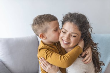 Anne ve sarılma ve öpüşme kanepede birlikte şirin oğlu