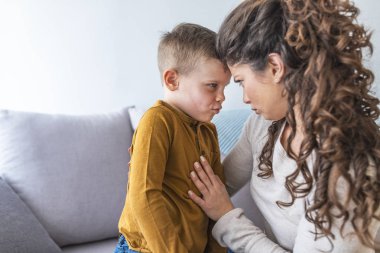 Anne ve rahatlatıcı ve kanepede birlikte oynayan sevimli oğlu