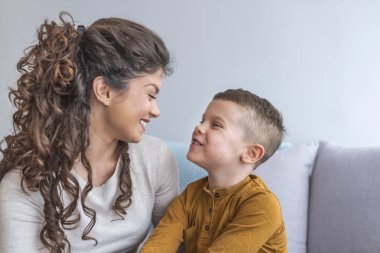 Anne ve rahatlatıcı ve kanepede birlikte oynayan sevimli oğlu