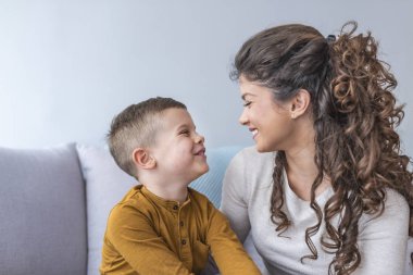 Anne ve rahatlatıcı ve kanepede birlikte oynayan sevimli oğlu