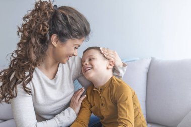 Anne ve rahatlatıcı ve kanepede birlikte oynayan sevimli oğlu