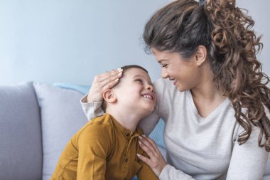 Anne ve rahatlatıcı ve kanepede birlikte oynayan sevimli oğlu