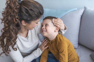 Anne ve rahatlatıcı ve kanepede birlikte oynayan sevimli oğlu