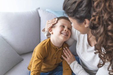 Anne ve rahatlatıcı ve kanepede birlikte oynayan sevimli oğlu