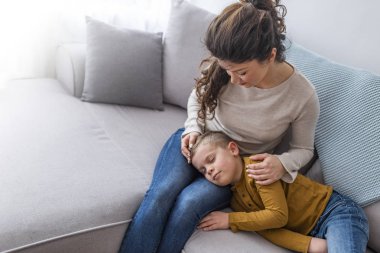 Tur bir anne kanepede uyuyan sevimli oğlu