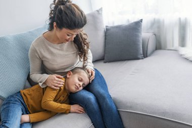 Tur bir anne kanepede uyuyan sevimli oğlu