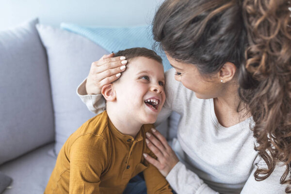 мама и милый сын расслабляются и играют на диване вместе
